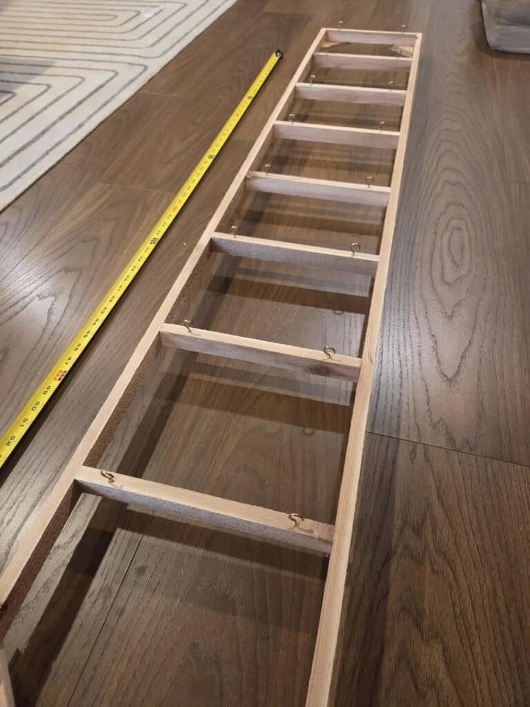 Underside of the cedar lattice showing small screw hooks along the bottom of each slat
