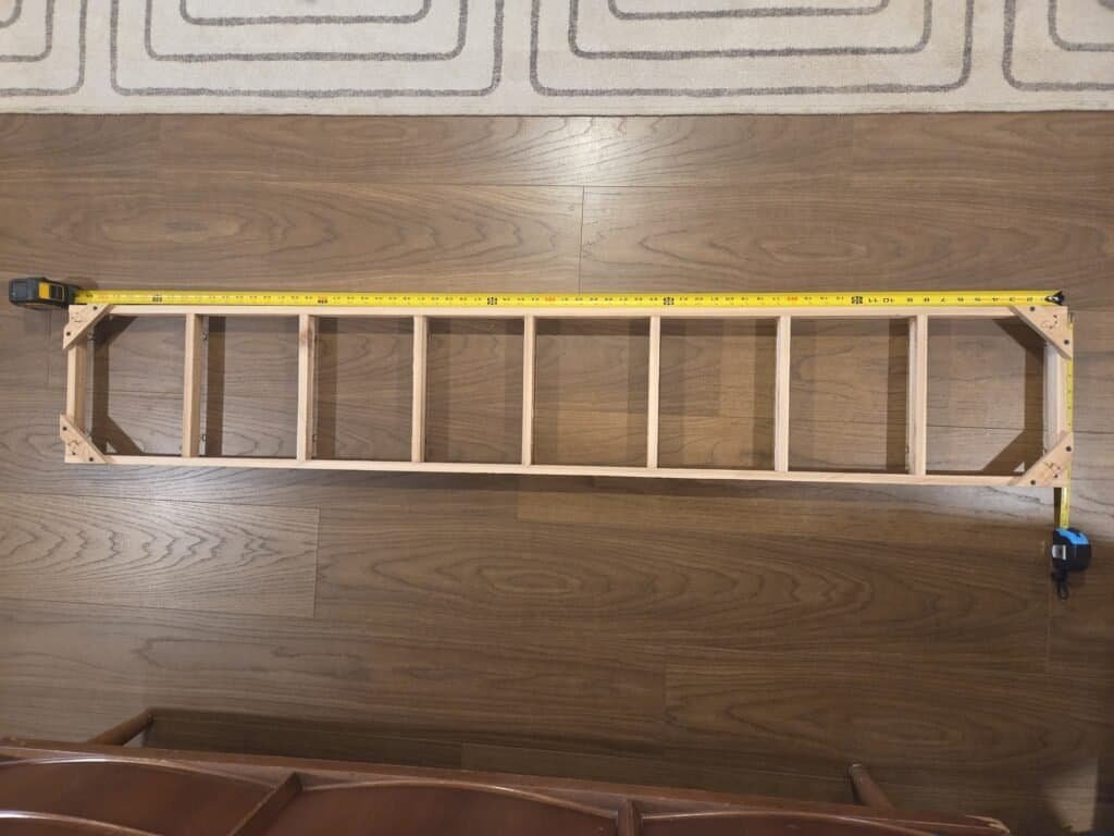 Cedar lattice rack frame laid flat with a tape measure showing its total length
